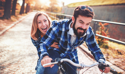 Couple in love. Romantic couple riding a bicycle in the autumn park. Love, dating, romance