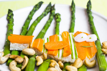 Funny healthy sandwich with cheese, carrots, asparagus and cashew nuts in the form of fish meal...