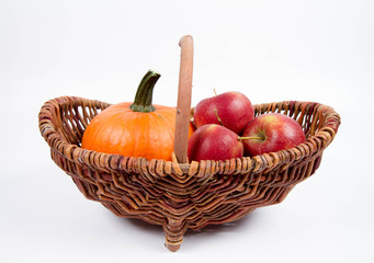 Basket full of apples and a pumpkin on a white background