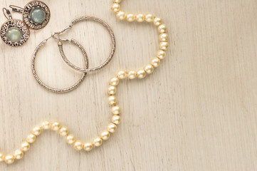 Woman's Jewellery. Frame with old vintage brooches, cameos, pearl beads, pearl earrings. Beautiful vintage jewelry on grey. Flat lay, top view