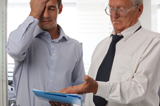 Portrait of an old senior experienced businessman with a young inexperienced colleague. Teamwork leading to success, finding solution, business concept.