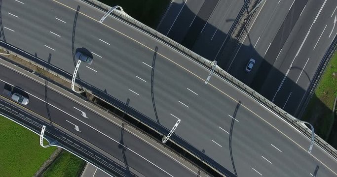 Semitrailer trucks and lorries driving on high speed roads crossing on different levels. Top view, summer season