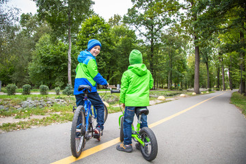 Two Kid boy outdoor ride bike.