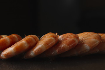 Shrimps on black background. Delicious seafood appetizer served boiled or grilled with spices. Close up. Top view