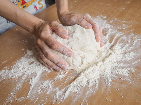 Female hands making dough for pizza
