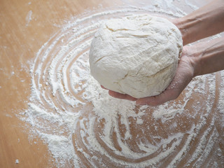 Female hands making dough for pizza
