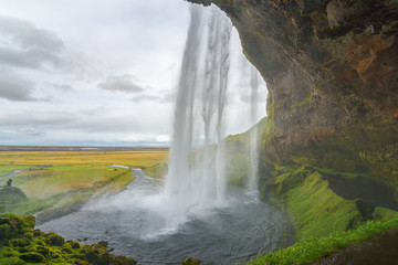 Amazing Seljalandsfoss waterfall from behind, Iceland