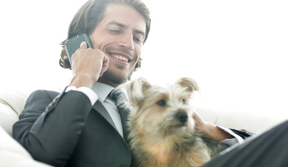 close-up of a businessman talking on the phone and holding his pet.