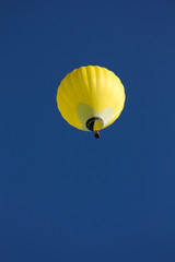 Yellow hot air ballon on blue sky.