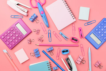 Stationary concept, Flat Lay top view Photo of school supplies scissors, pencils, paper clips,calculator,sticky note,stapler and notepad in pastel tone on pink background with copy space, flat lay