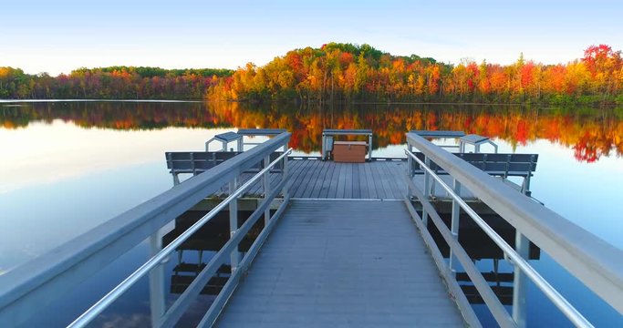 Flying down dock toward breathtaking Autumn colors, Fall splendor, aerial flyover.
