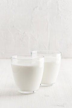 Two glasses with milk on the white wooden table