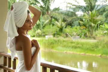 Happy and beautiful woman on the balcony after shower