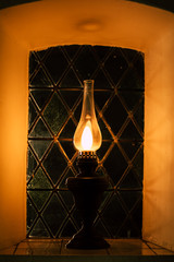 Fototapeta na wymiar hopeful mystic romantic oil lamp in cathedral window darkness