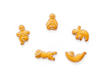 Gingerbread cookies in shape of yoga asanas on white background top view copyspace
