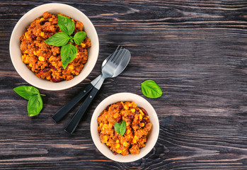 Bowls with delicious chili con carne on table