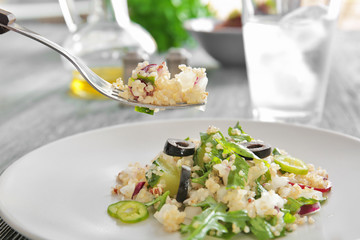 Eating of delicious quinoa salad, closeup