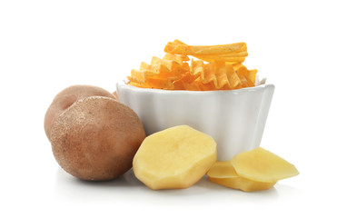 Bowl with crispy chips and raw potato isolated on white