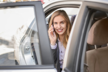 Young businesswoman talking on mobile phone in car