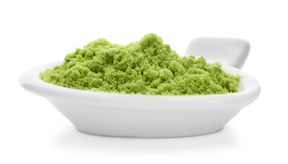Bowl with wheat grass powder on white background