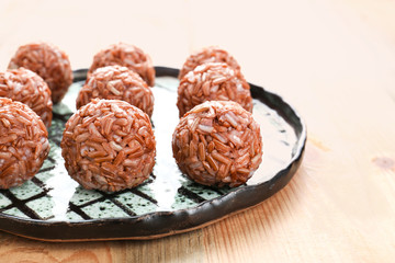 Plate with brown rice balls on table