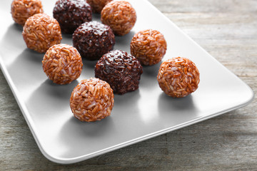 Plate with red and brown rice balls on table