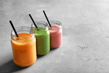 Jars with yummy smoothie on table