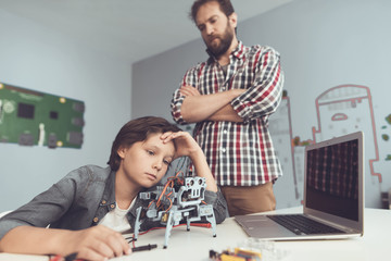 The boy hurt the robot. A man severely chastises the boy, explaining to him his mistakes