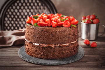 Slate plate with delicious chocolate cake on table