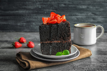 Plates with piece of delicious chocolate cake on table
