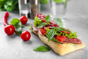 Delicious sausage sandwich on light background