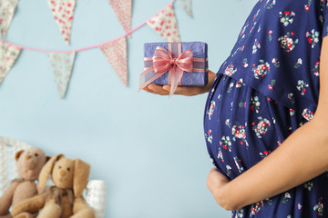 Pregnant woman holding gift at baby shower party
