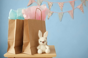 Shopping bags and toy rabbit on stool