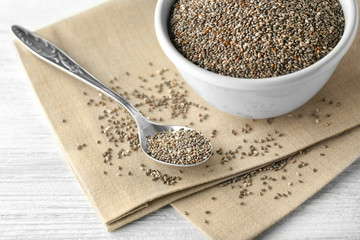 Bowl and spoon with chia seeds on table