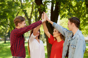 Happy young friends teamwork. Group of man amd woman with hands together doing give high five gesture. Friendship forever, togetherness, youth team , success concept