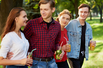 Group of young people with detox cocktails spend time together at summer. Friendship, youth lifestyle, vegetarian diet, fitness food on the go, successful weight loss concept