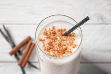 Vanilla and cinnamon protein shake in glass on table, closeup