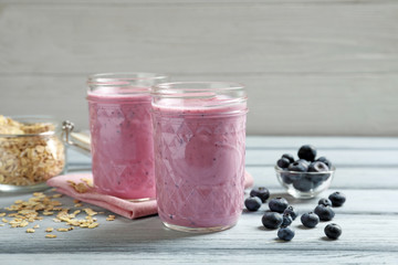 Jars with berry protein shakes on table