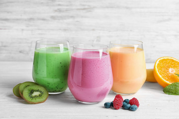 Glasses with different protein shakes on table