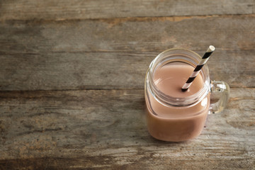 Jar with tasty protein shake on wooden table