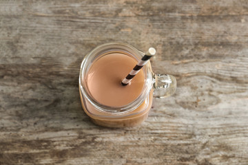 Jar with tasty protein shake on wooden table