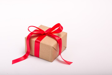 Square single one present gift box wrapped in craft paper with satin red ribbon bow for christmas,...