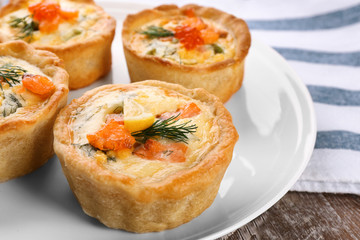 Tasty salmon tartlets on plate, closeup