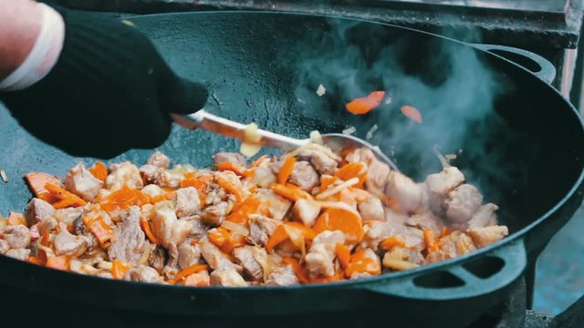 The most delicious Uzbek pilaf with carrots rice and meat is brewed in huge tub at the festival food court