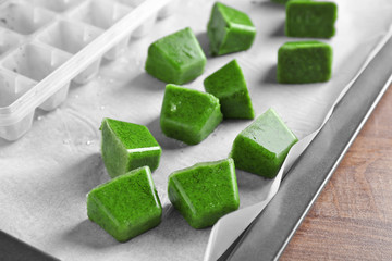 Frozen vegetable puree and ice tray on paper
