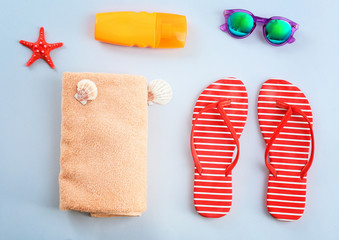 Composition with towel and summer accessories on light background