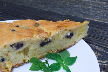 Slice homemade pie and mint on white plate