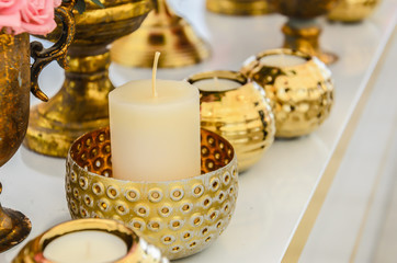set of new white candles in a vintage candlestick in the form of a bronze (golden) bowl