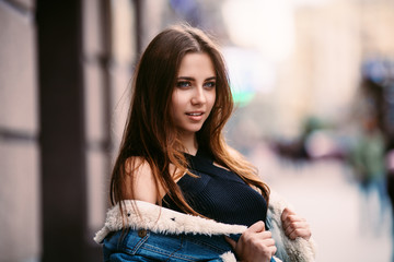 Amazing joyful pretty girl with long brunette hair. posing outdoor. denim jacket,brunette hair Close up fashion street stile portrait