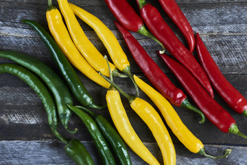 Top View Pile of Fresh Red, green, yellow Hot Chili on blue wooden background. Texture or template...